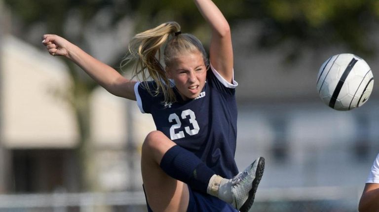 Julie Strianese of Oceanside knocks the ball down in front...