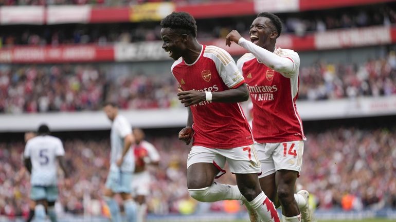 Arsenal's Bukayo Saka, left, celebrates with teammate Arsenal's Eddie Nketiah...