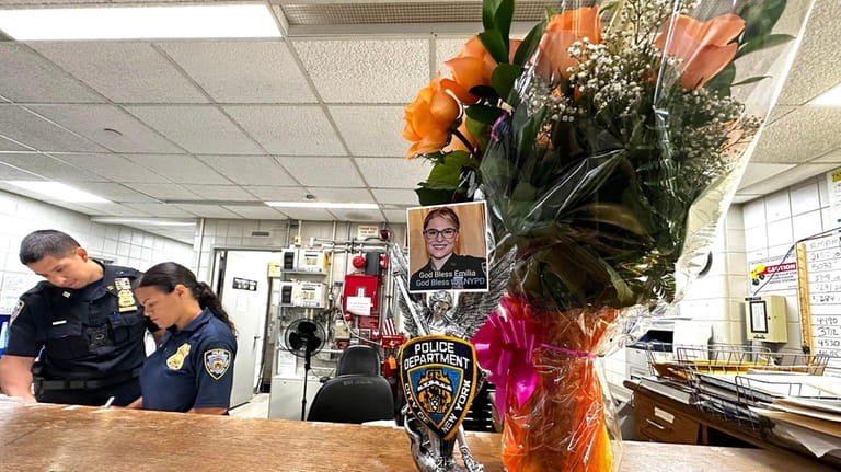 Flowers and a picture of fallen 102nd Precinct officer Emilia...
