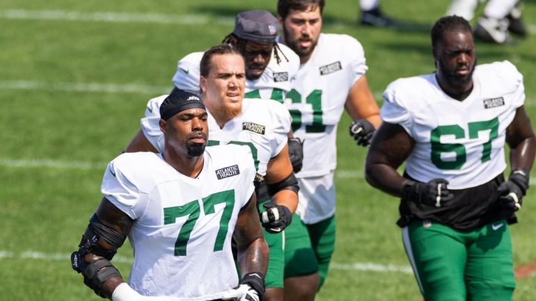 Jets offensive tackle Tyron Smith, left, jogs during training camp on Aug....