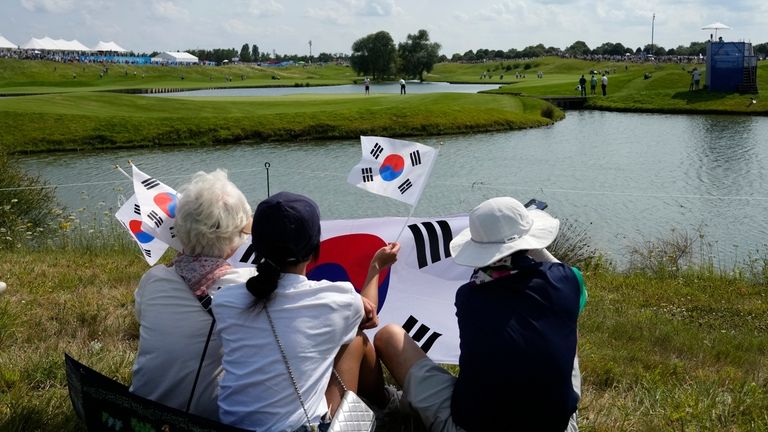 Korean fans watch Tom Kim, of South Korea, play the...