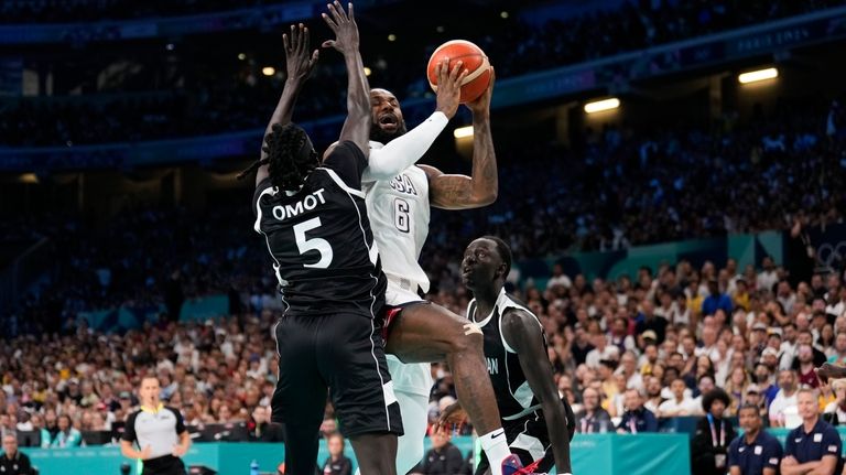 LeBron James, of the United States, shoots over Nuni Omot,...