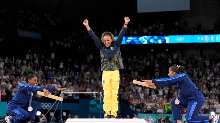 Silver medalist Simone Biles, of the United States, left, and...