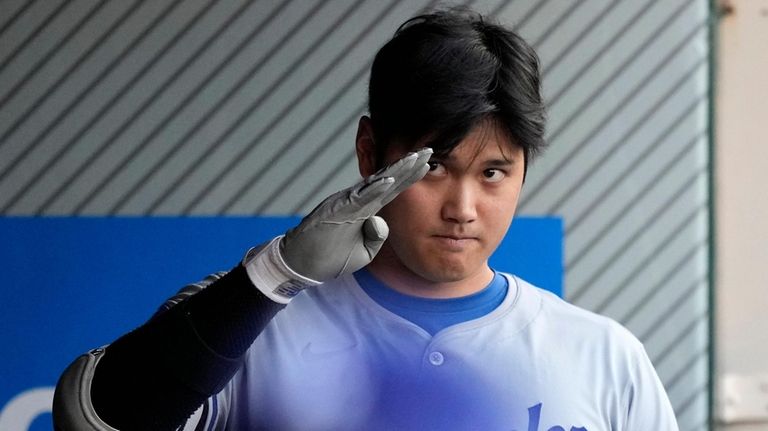 Los Angeles Dodgers' Shohei Ohtani gestures in the dugout prior...