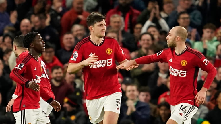 Manchester United's Harry Maguire, centre, celebrates with his teammates after...