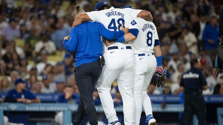 Los Angeles Dodgers relief pitcher Brusdar Graterol (48) is helped...