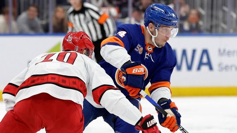 Bo Horvat of the Islanders skates against Sebastian Aho of the Hurricanes in...