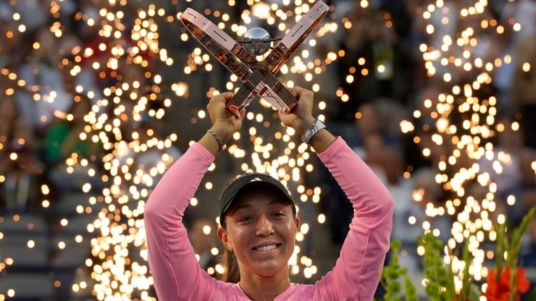 Pyrotechnics fire behind Jessica Pegula, of the United States, as...