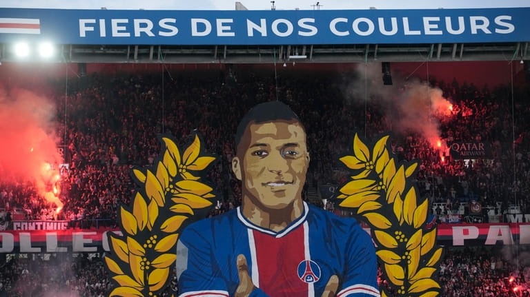 A giant painting depicting PSG's Kylian Mbappe is displayed before...