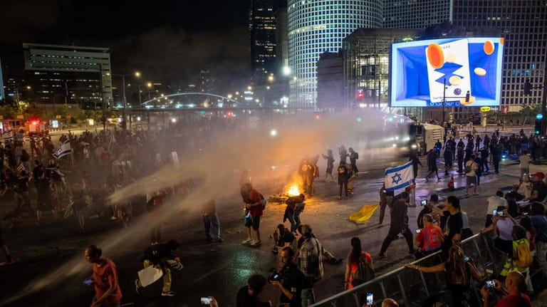 Police use water cannon to disperse demonstrators during a protest...