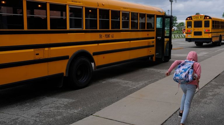 A student races to the school bus after dismissal, Thursday,...