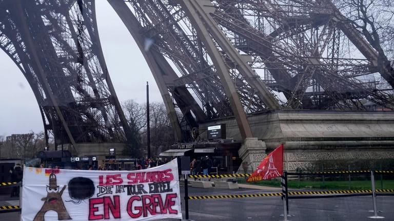 A union banner reads "Eiffel Tower employees on strike" outside...