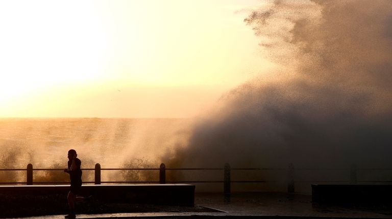 Waves break over Sea Point's promenade in Cape Town, South...