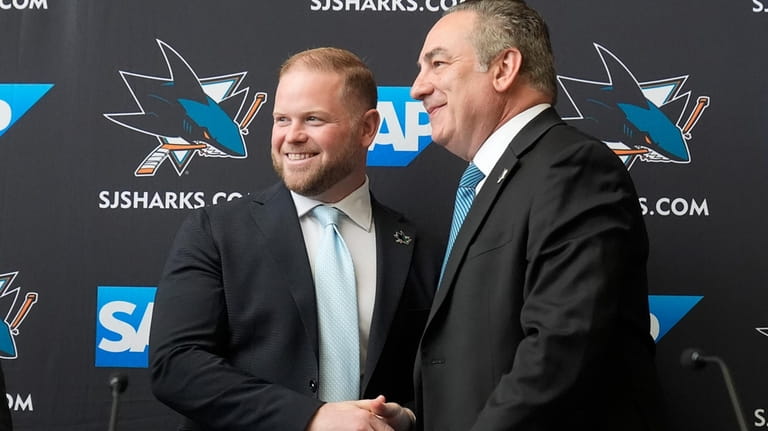 Ryan Warsofsky, left, shakes hands with San Jose Sharks president...