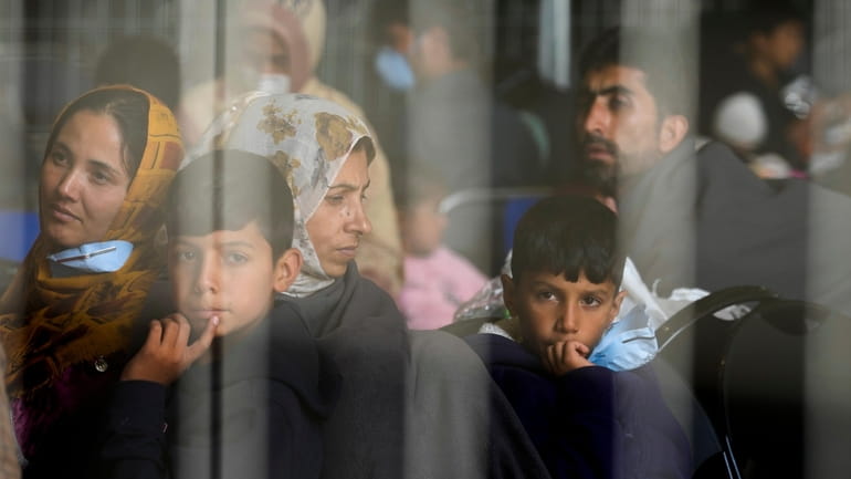 Evacuees from Afghanistan wait with other evacuees to fly to...