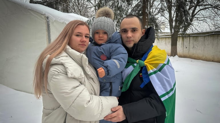 Kateryna Dmytryk, left, and husband Artem Dmytryk hold their son,...