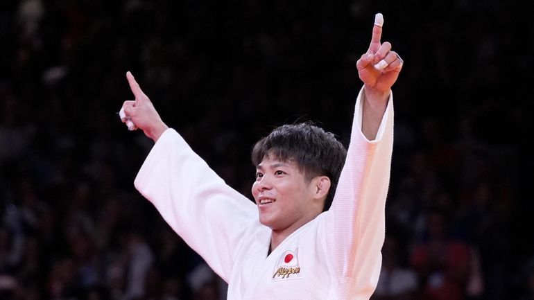 Japan's Hifumi Abe celebrates after defeating Brazil's Willian Lima during...