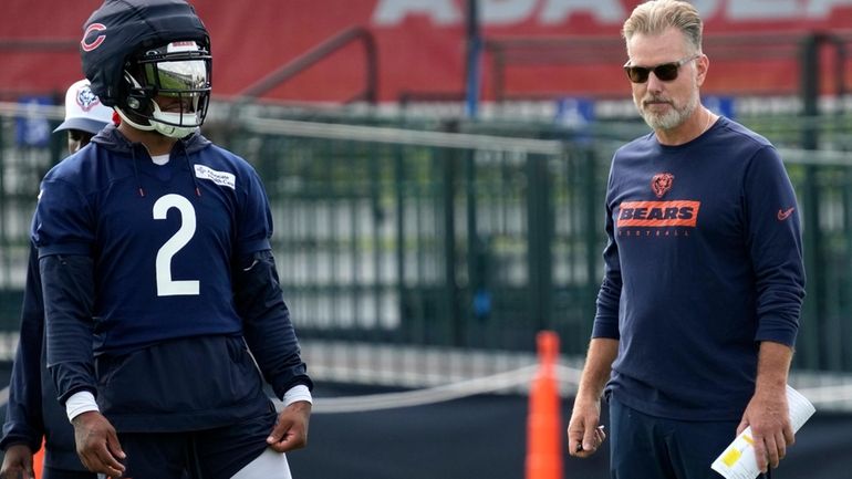 Chicago Bears wide receiver DJ Moore, left, watches teammates as...