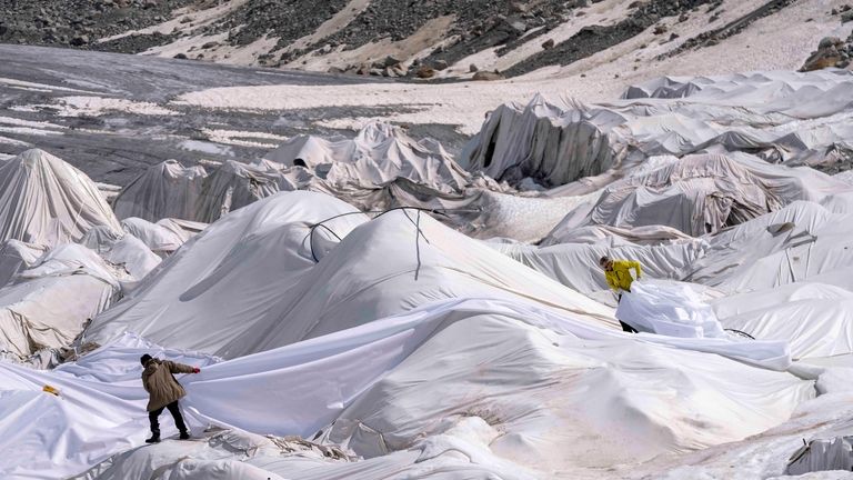 Workers prepare sheets at the Rhone Glacier near Goms, Switzerland,...