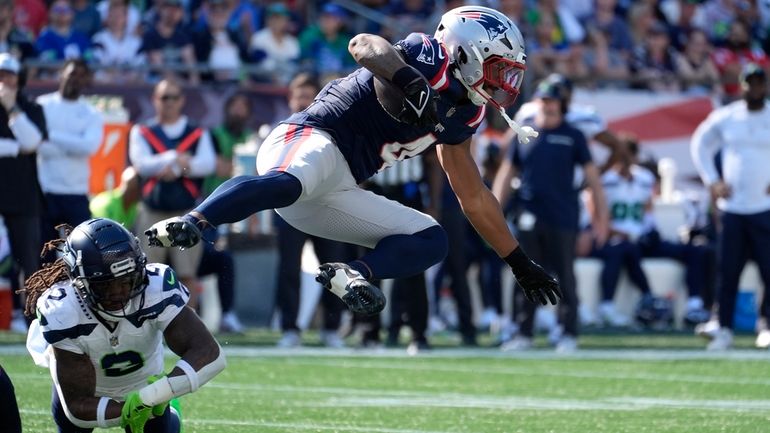 New England Patriots running back Antonio Gibson, right, is brought...