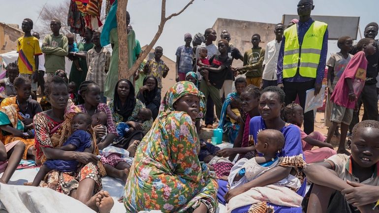 South Sudanese who fled from Sudan sit outside a nutrition...