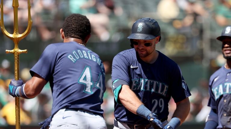 Seattle Mariners catcher Cal Raleigh (29) celebrates with Julio Rodríguez...