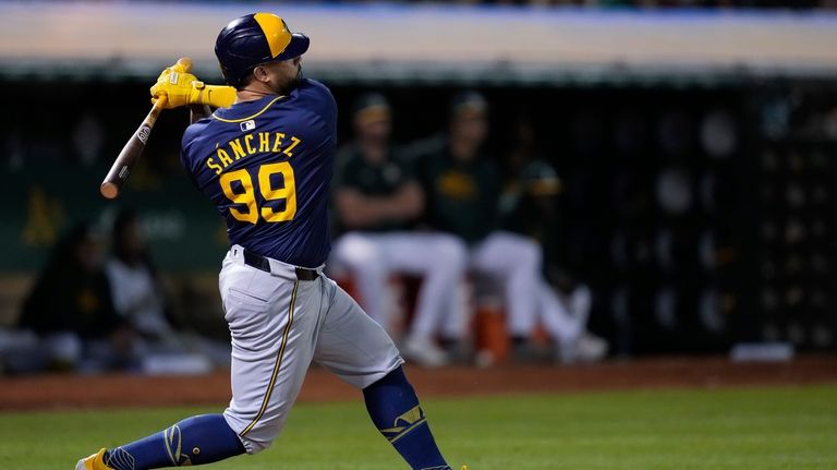 Milwaukee Brewers' Gary Sánchez hits a three-run triple during the...