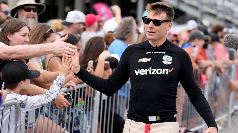 Driver Will Power, right, greets fans before an IndyCar auto...