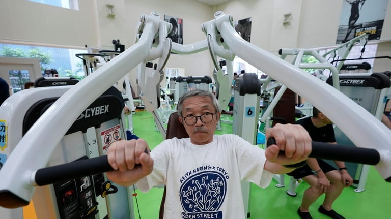 Toshiyuki Honma, 70, uses a chest press machine as he...