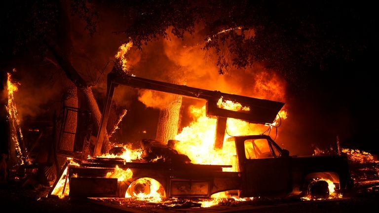 A vehicle burns from the Airport Fire Tuesday, Sept. 10,...