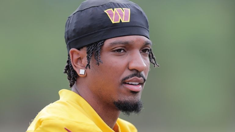 Washington Commanders quarterback Jayden Daniels prepares to warm up during...