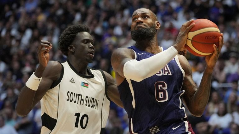 United States' forward LeBron James, right, goes for the basket...