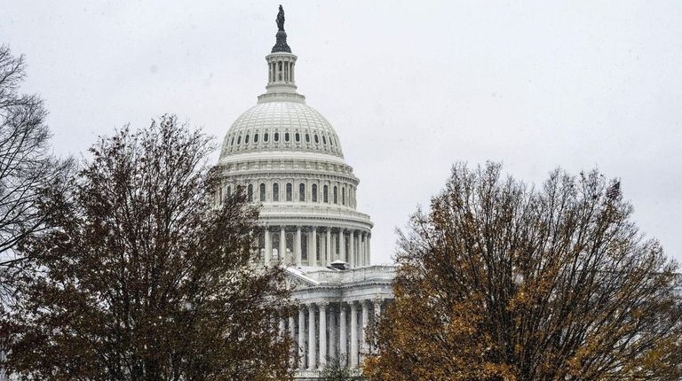 Snow falls in front of the U.S. Capitol in Washington...