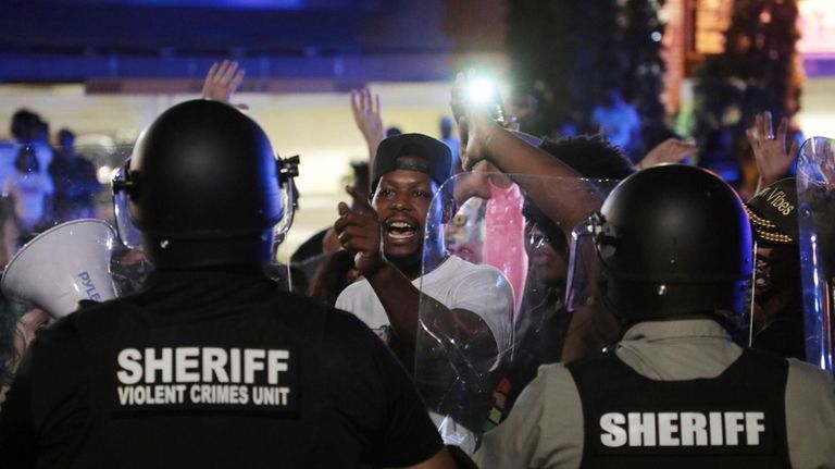 A protester confronts police officers in riot gear on Thursday...