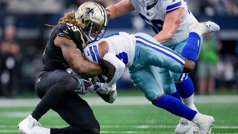 New Orleans Saints defensive end Chase Young, left, tackles Dallas...