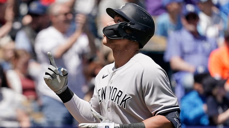 The Yankees' Aaron Judge celebrates as he crosses the plate...