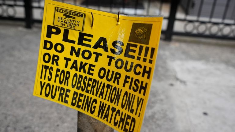 A sign is posted near to a pool of water...