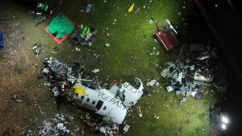 The debris at the site where an airplane crashed with...