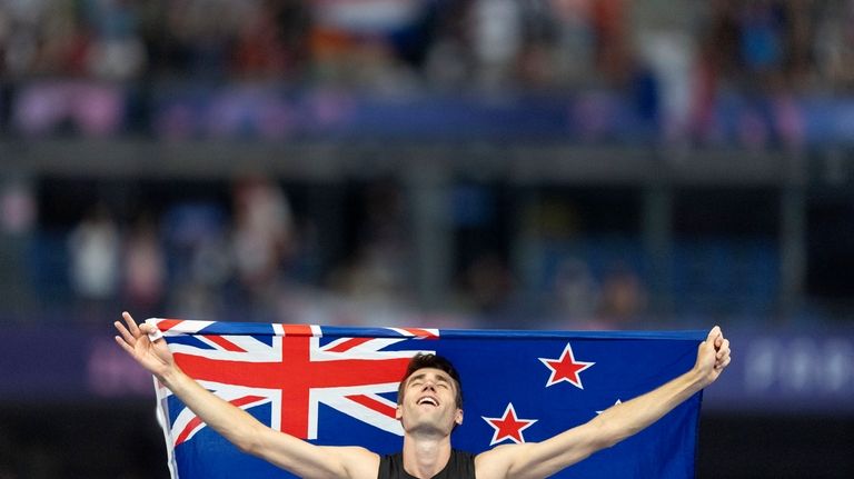 Hamish Kerr, of New Zealand, celebrates after winning the gold...