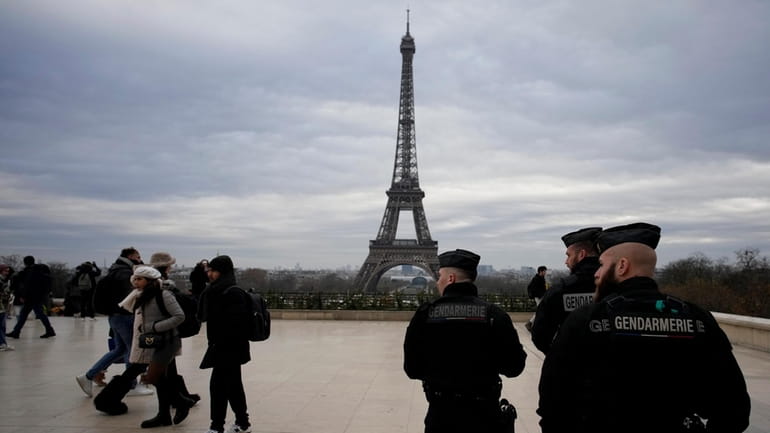 French gendarmes patrol the Trocadero plaza near the Eiffel Tower...