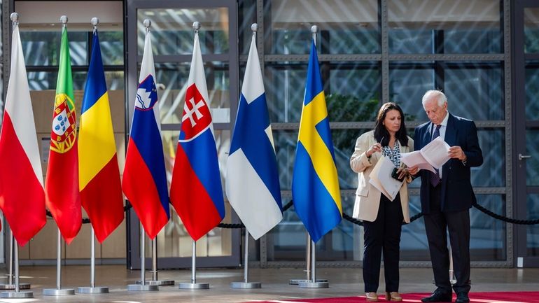 European Union foreign policy chief Josep Borrell, right, reads a...