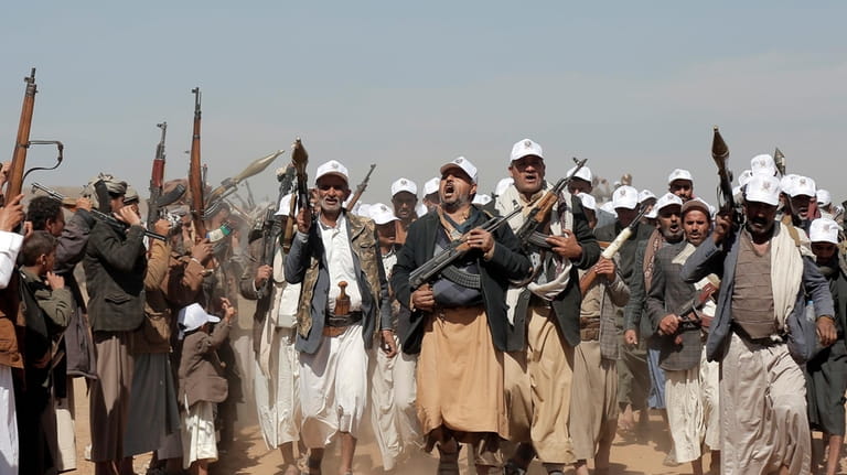 Houthi fighters march during a rally of support for the...