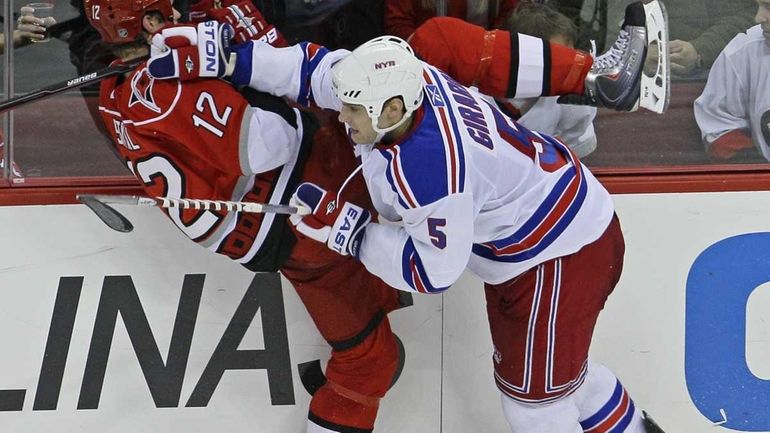 Carolina Hurricanes' Eric Staal is checked against the boards by...