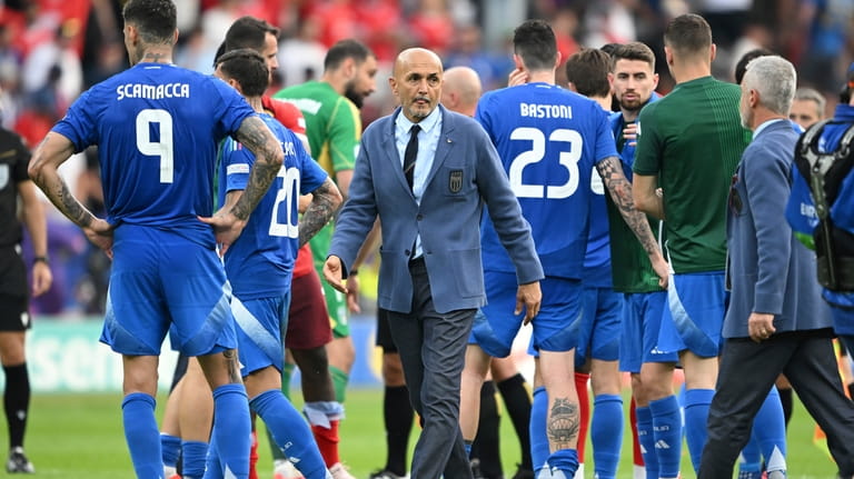 Italy's coach Luciano Spalletti, center, walks between his players after...