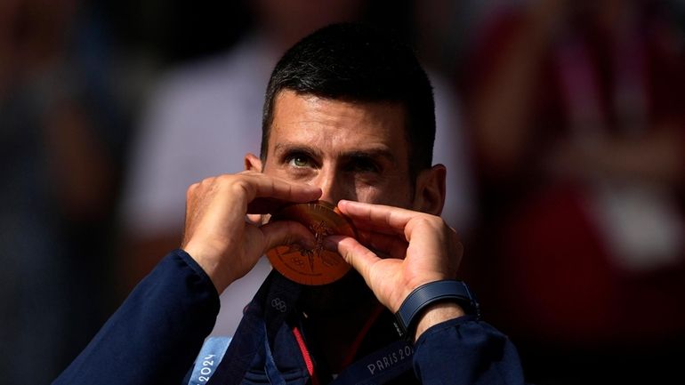 Serbia's Novak Djokovic kisses his gold medal after defeating Spain's...