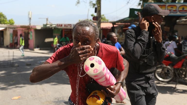 A demonstrator is affected by tear gas fired by police...