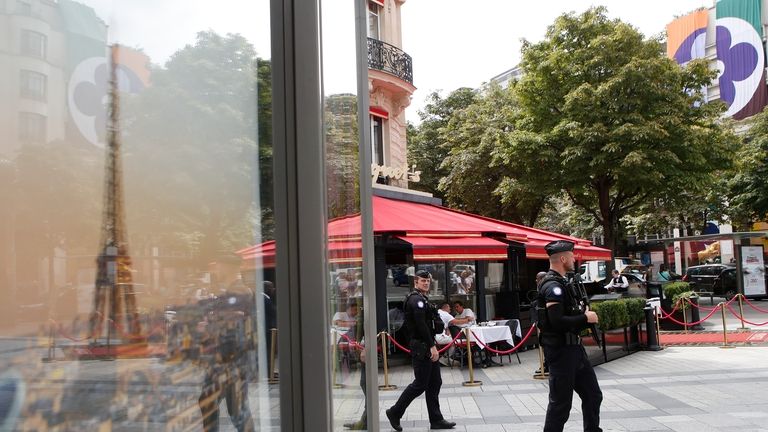 Police officers patrol on the Champs-Elysees avenue ahead of the...