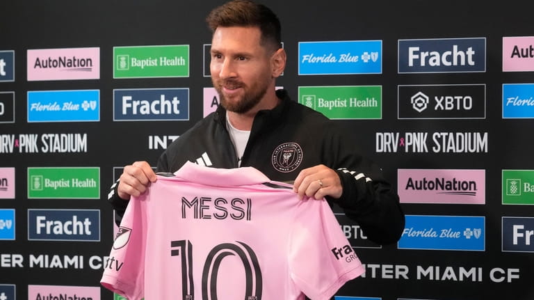 Inter Miami's Lionel Messi holds up his team jersey during...