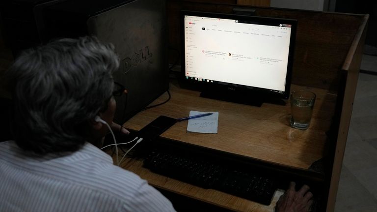 A Pakistani waits to open a page on a desktop...