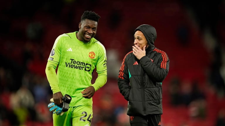 Manchester United's goalkeeper Andre Onana smiles at the end of...
